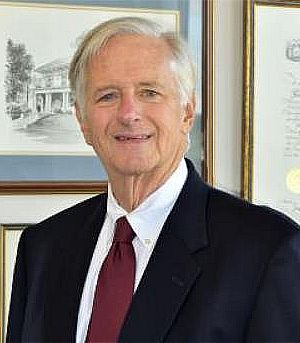 Photo of older white haired gentleman in dark suit
