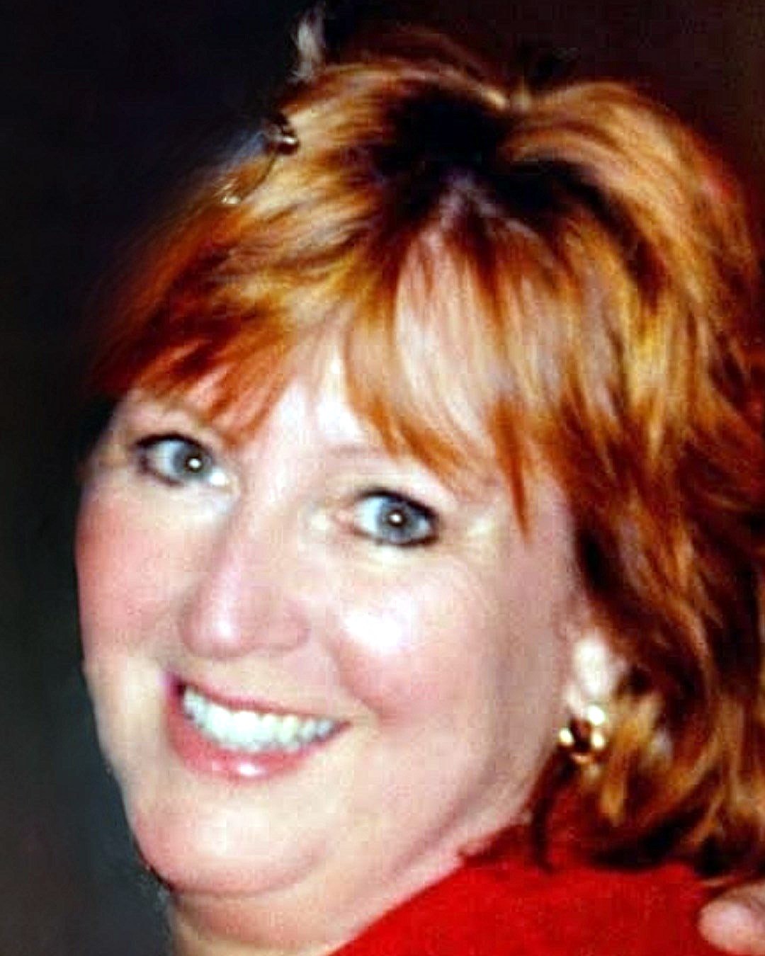 Image of red haired smiling woman in red shirt